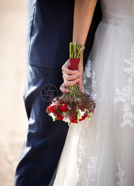 新娘拥抱郎和举行婚礼花束的照片图片