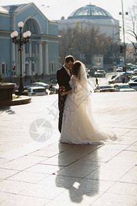 在寒冷的阳光天在街上拥抱已婚夫妇的照片图片