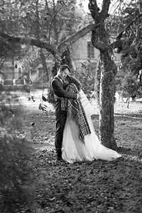 秋天公园的幸福新娘和郎拥抱树下的黑白照片图片