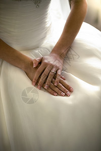 紧贴新娘双手的肖像躺在白色婚纱上的礼服图片