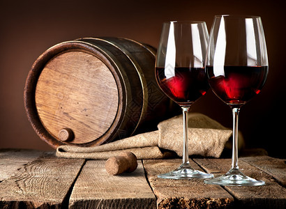 木桌上的红酒桶和葡萄杯图片