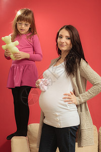 怀孕母亲和幸福概念孕妇为未出生的婴儿穿小鞋靴怀孕妇女小孩在背地里玩耍图片