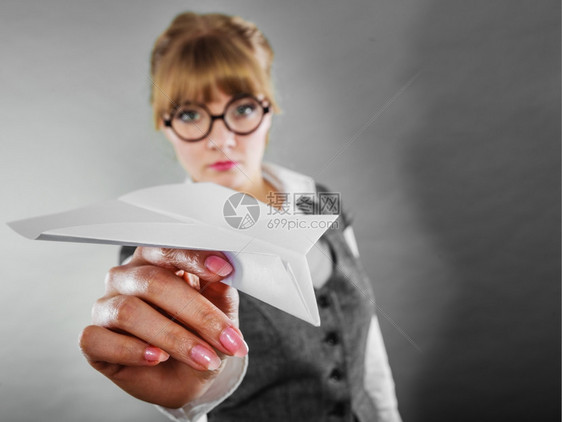 戴眼镜的女人手拿着一架纸飞机图片