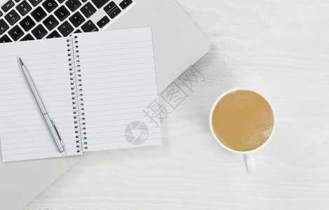 笔记本电脑咖啡和空白笔记本的高角度视图银笔放在锈白色桌面上xAxA图片