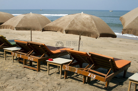 印度果阿海滩上的木板床和遮光罩图片