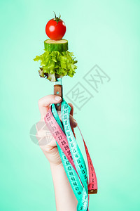 饮食和减肥概念糖尿病女手与素食和彩色的测量磁带绿色蓝背景图片