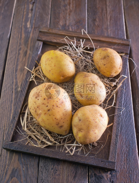 木箱和桌上的生土豆图片