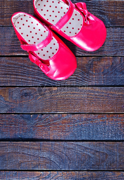 木制背景的红婴儿鞋图片