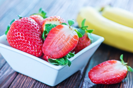 草莓特写木制桌上的香蕉和草莓背景