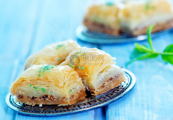 Baklava土耳其在金属板和桌子上的甜点图片