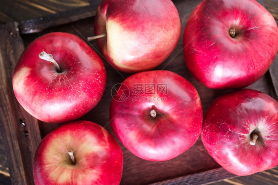 木制桌上的新红苹果图片