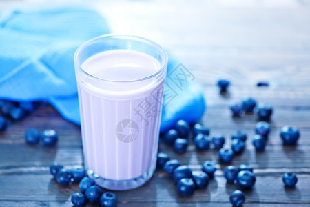 玻璃和桌子上的蓝莓酸奶图片