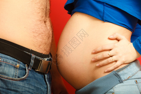 孕妇和她的丈夫父母用她们的腹腔互相触碰侧视图片