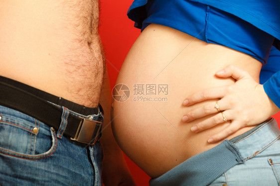 孕妇和她的丈夫父母用她们的腹腔互相触碰侧视图片
