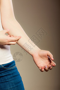 健康问题年轻女人用过敏皮疹抓痒的手臂图片