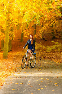 时尚女郎在公园骑着自行车图片