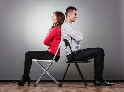 男女意见不一夫妻在争吵后坐椅子背对上图片