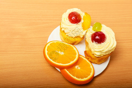 果美甜食饼干蛋糕奶油和水果作为甜点食物上面加橙子盘上图片