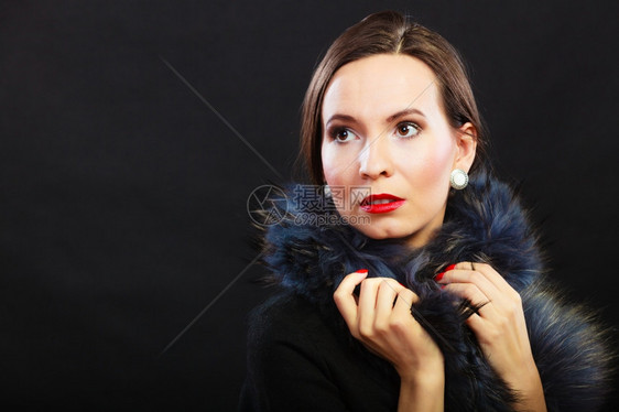时装和美穿皮大衣红嘴唇和钉子的女人黑色背景的女士倒影风格肖像图片