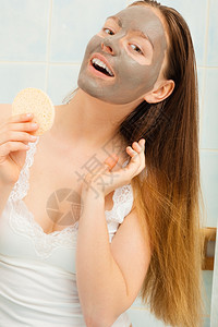 洗手间戴面罩的年轻女子用海绵除泥图片