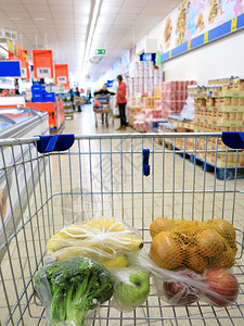 水果蔬菜超市超市里装有蔬菜和水果的购物车背景