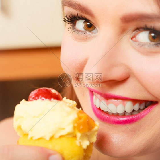 女人吃着美味的蛋糕上面有甜的奶油和水果美味的贪食观念女人吃着美味的甜饼图片