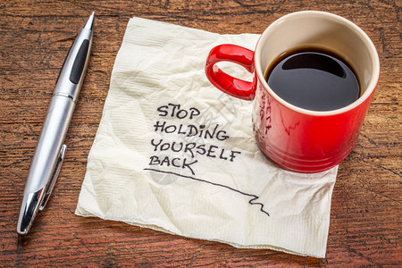 停止克制自己动机笔迹在餐巾纸上和一杯咖啡图片