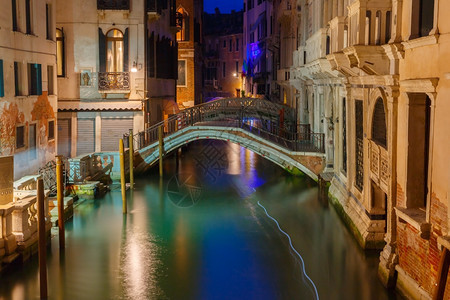 晚上在威尼斯的横向运河和行人桥意大利有街道灯光照亮的桥和房屋图片
