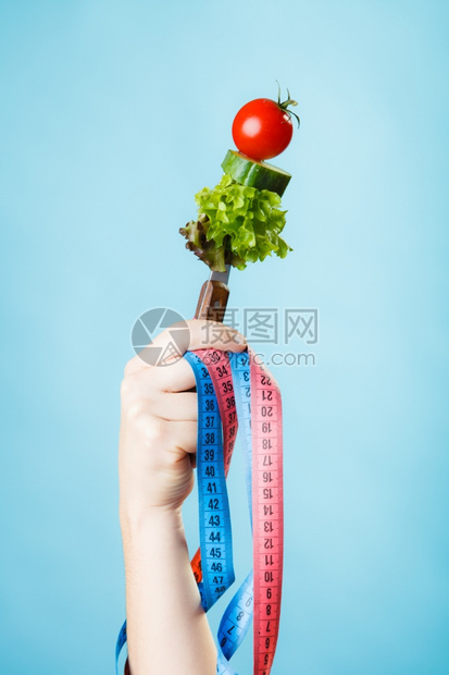 饮食和减肥概念糖尿病女手与素食和彩色测量磁带蓝背景图片