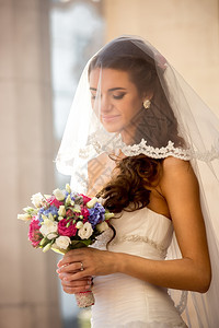 在阳光明媚的日子带着婚礼花束的可爱黑发新娘图片