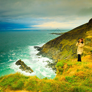 爱尔兰独白海岸女游客站在岩石悬崖上海洋CoCork爱尔兰欧洲自然界的美丽海景图片