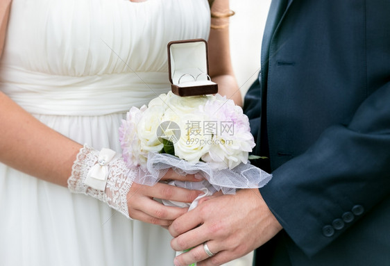 新娘和郎用金戒指举行婚礼花束图片