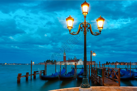 Gondolas由圣马克广场和乔治马吉奥雷教堂在意大利威尼斯环礁湖天明时的背面挂起图片