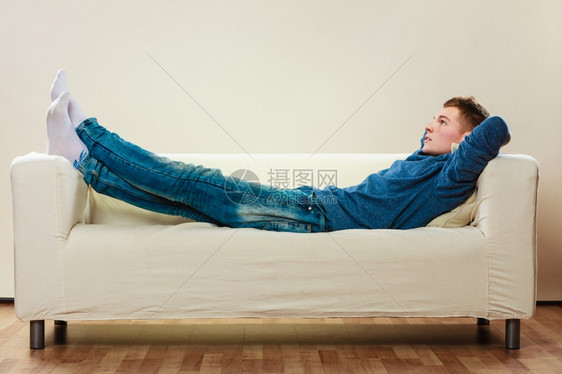 年轻英俊的沉睡男子在沙发上觉和做梦图片
