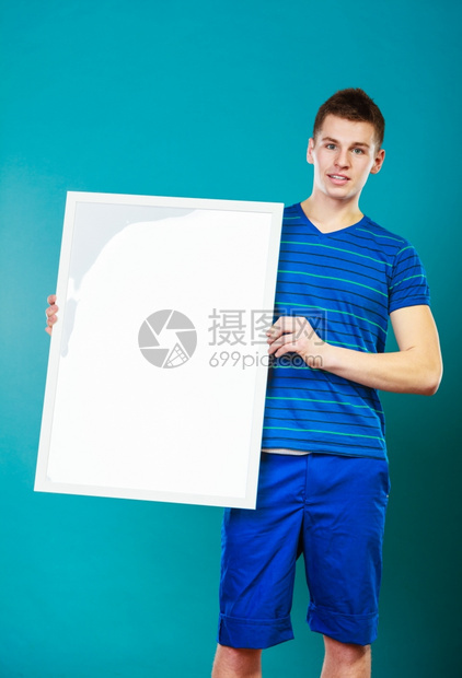广告概念年轻人持有空白演示文稿板男模型显示横幅标志广告板复制蓝色文本的空间图片