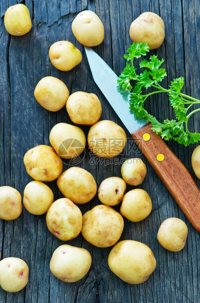 木板上的生土豆和刀图片