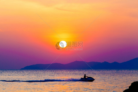 在日落时海面上有行驶的摩托艇图片