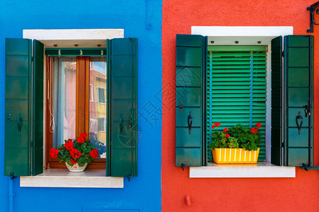 威尼斯人意大利威尼斯著名的布拉诺岛近身装饰着花朵窗户和百叶的丰富多彩房屋背景