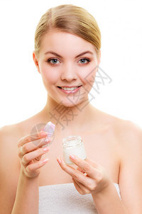 乳液水罐的年轻女金发孩照顾干燥的皮肤使用湿润的乳霜隔离图片