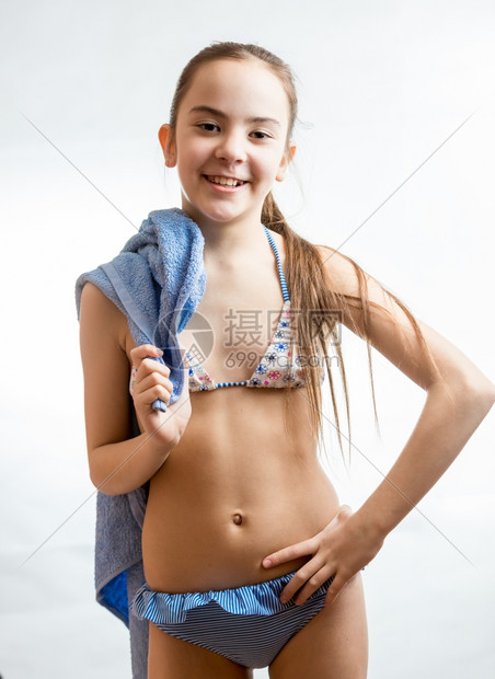 穿着泳衣的快乐可爱女孩穿着蓝色沙滩毛巾图片