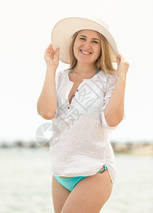 穿着白衬衫和在沙滩上放松的美丽瘦女人图片