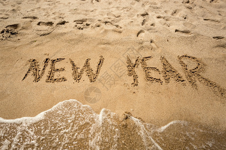 新年在沙滩上写作被海浪冲洗图片