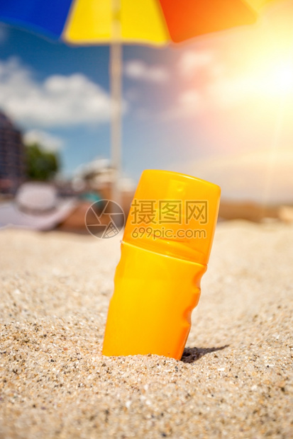 沙滩上黄色防晒油瓶的近镜头图片