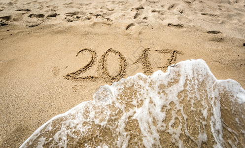 2017年的紧贴镜头写在被海浪冲走的沙子上图片