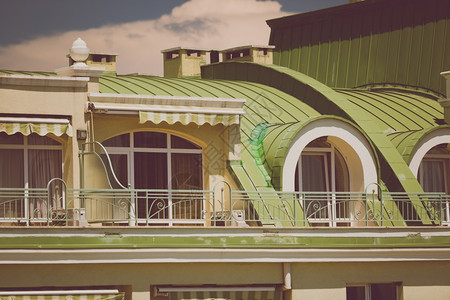 经典建筑的绿色金属屋顶下美丽阳台图片