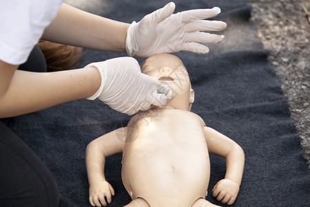 在婴儿假人身上展示CPR图片