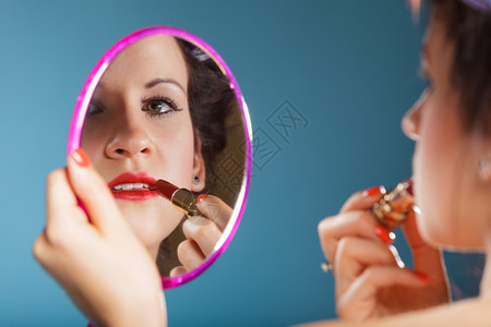 化妆美容程序和概念女脸部的缝合分照镜子的女生涂红唇膏化妆图片