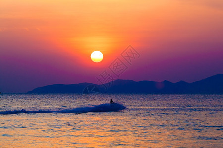 在日落时海面上有行驶的摩托艇图片