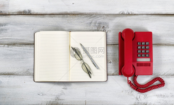 古老的红色电话注纸笔和在生锈的白木板上阅读眼镜高角度视图xAxA图片