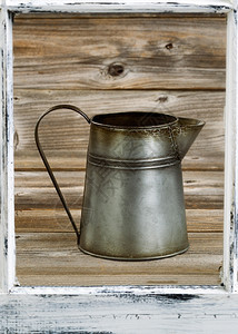 旧金属咖啡壶前面有旧的白色窗头背景为硬木有垂直布局图片